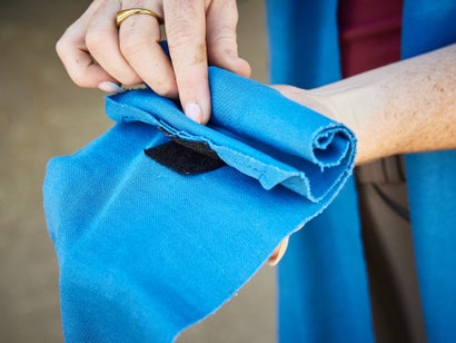 Pre-wrapping a blue stable bandage prior to putting it on a horse's leg. Connecting the velcro correctly and wrapping into the velcro.  