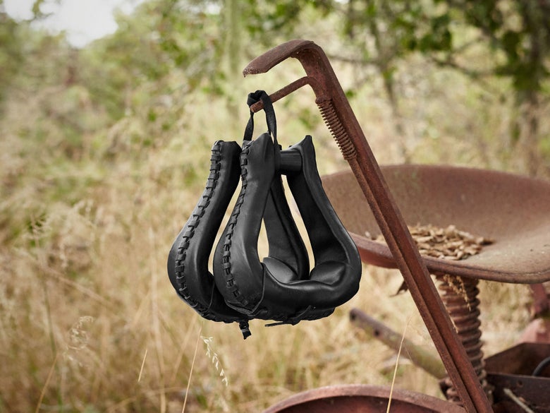 The Tucker Leather Laced ErgoBalance Western Stirrups hanging from a tractor