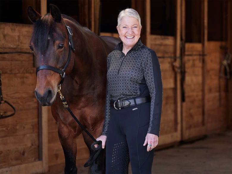 Woman standing with a bay horse wearing a Kerrits sun shirt