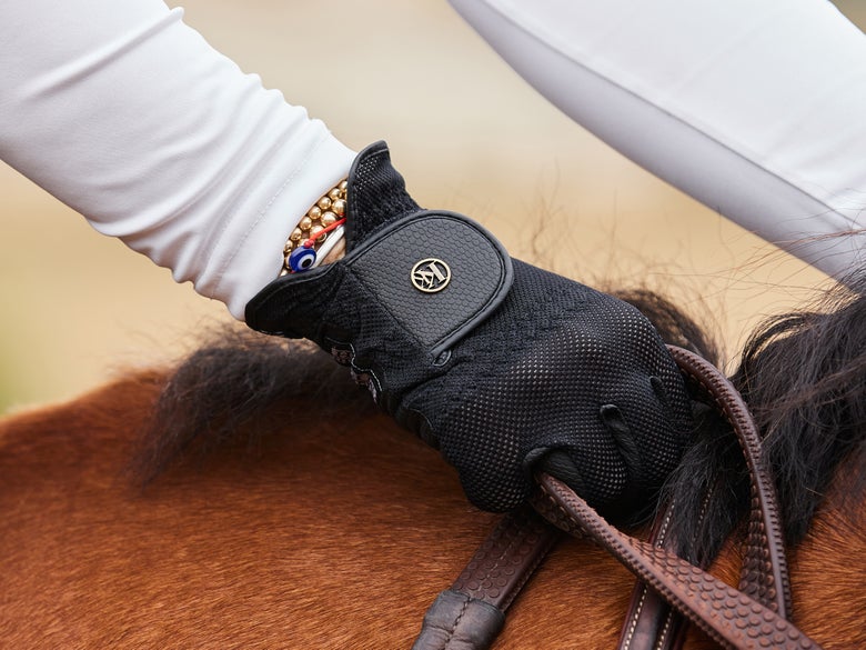 A rider wearing summer riding gloves. 