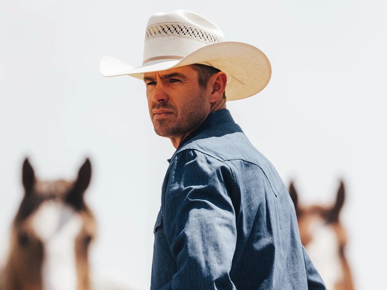 A man wearing the Resistol Wildfire USTRC Straw Cowboy Hat 4.25
