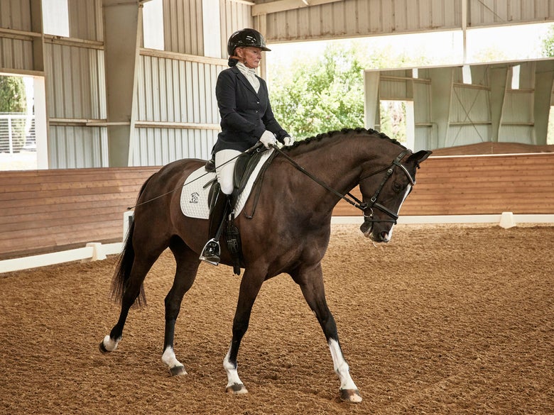 Riding Warehouse sponsored rider Jackie Eckhaus riding in dressage show attire.