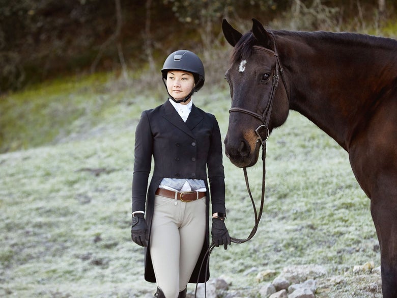 A rider and her dark bay horse dressed in black hunter derby competition attire.