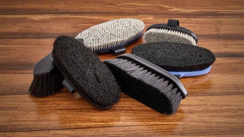 Haas brushes that are good at adding shine laid out on a wood table.