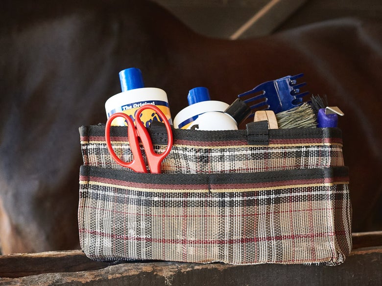 A fully stocked grooming tote sitting in cross ties.