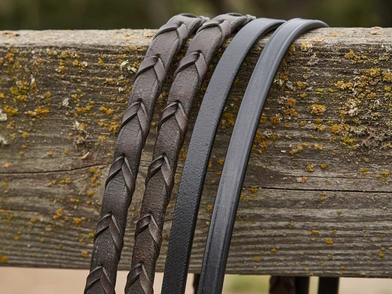 Leather reins, side by side, with braided leather reins on the left and smooth leather reins on the right. 