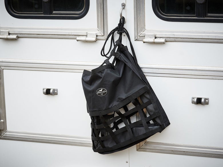The Professional's Choice Scratch Free Hay Bag hanging outside a horse trailer.
