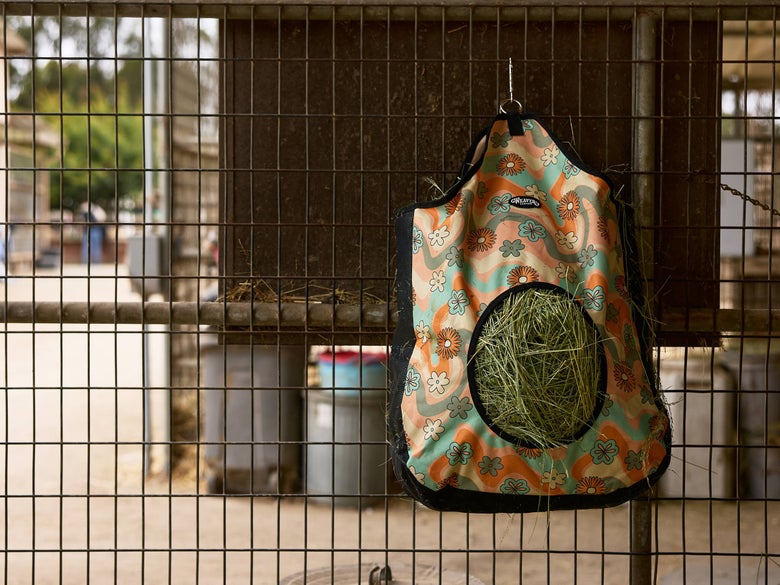The Weaver Breathable Easy Fill Hay Bag hanging in a stall.