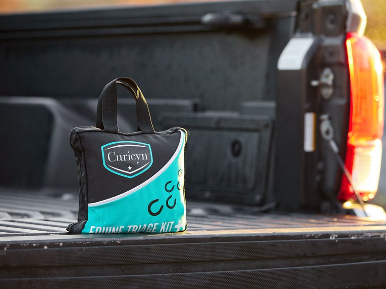 The Curicyn Equine Triage First Aid Kit sitting in an open truck bed.