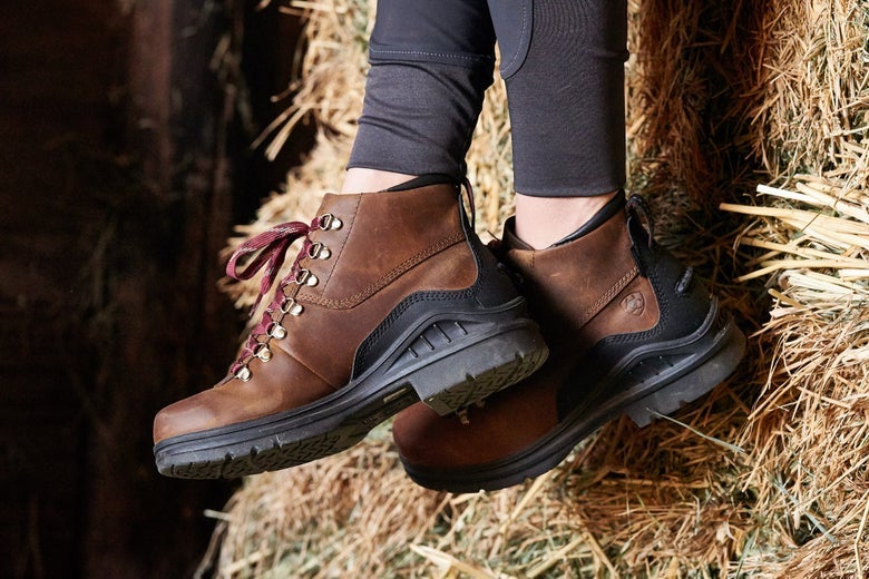 Women sitting on a bale of hay wearing the Ariat Barnyard Lace Boots.