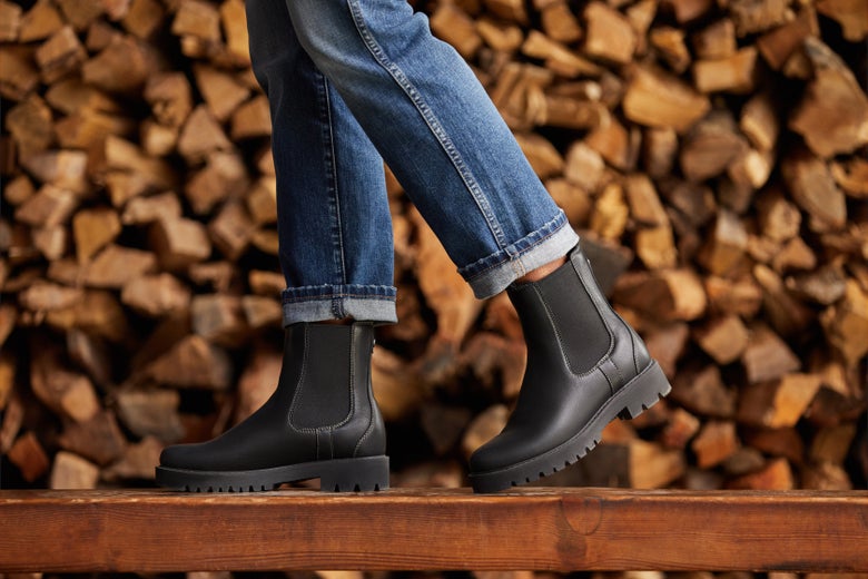 A woman walking in the Ariat Wexford Lug Mid Waterproof Boots with logs in the background. 