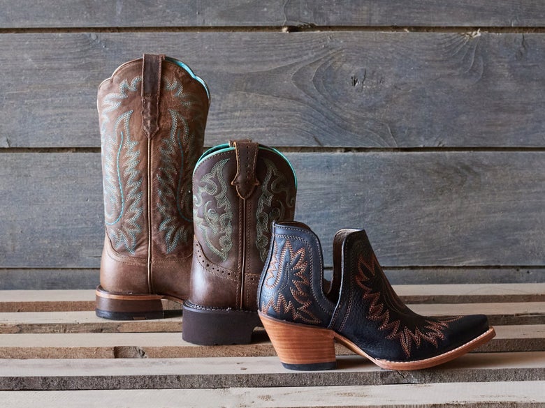 Three different heights of cowboy boots placed in a row