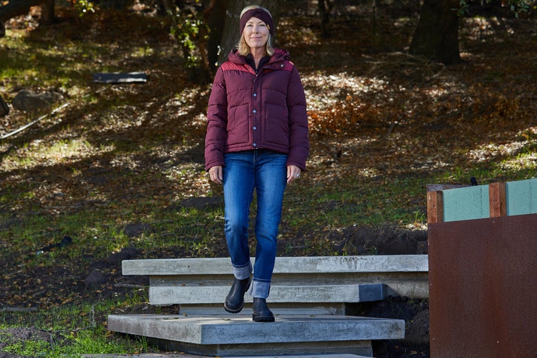 Woman walking down outdoor stairs wearing the Ariat Frontier Puffer Jacket.