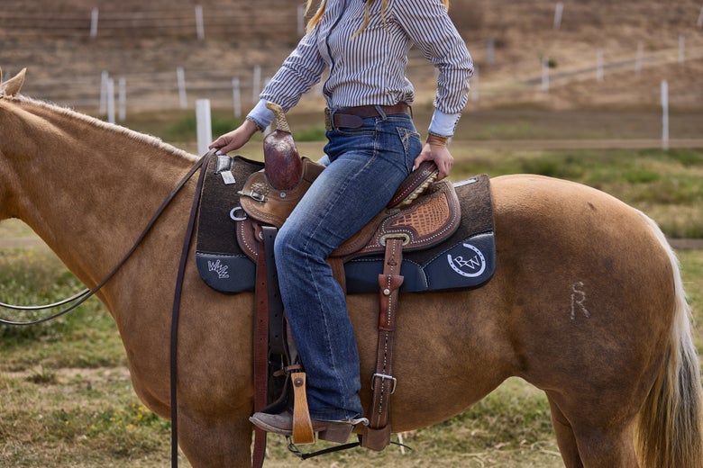 A rider on a palomino horse with the Riding Warehouse by Best Ever OG Pad.
