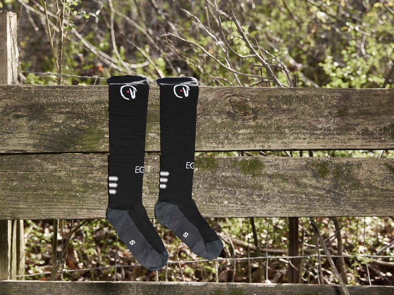 The EGO7 Knee High Tall Boot Air socks resting on a wooden fenceline.