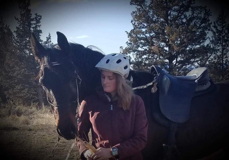 Sanoma Blakeley with her dark bay horse on an endurance ride.