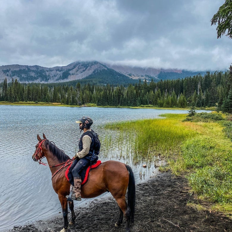Stevie Delahunt's husband Dylan on horseback at a lake.