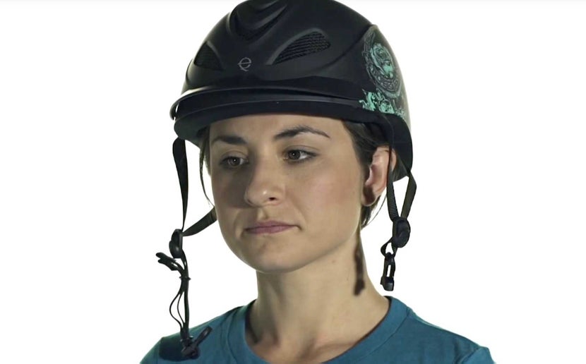 An unbuckled helmet sitting on woman's head.