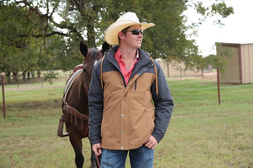 Cowboy leading his horse, wearing an insulated Cinch Ski Jacket. 