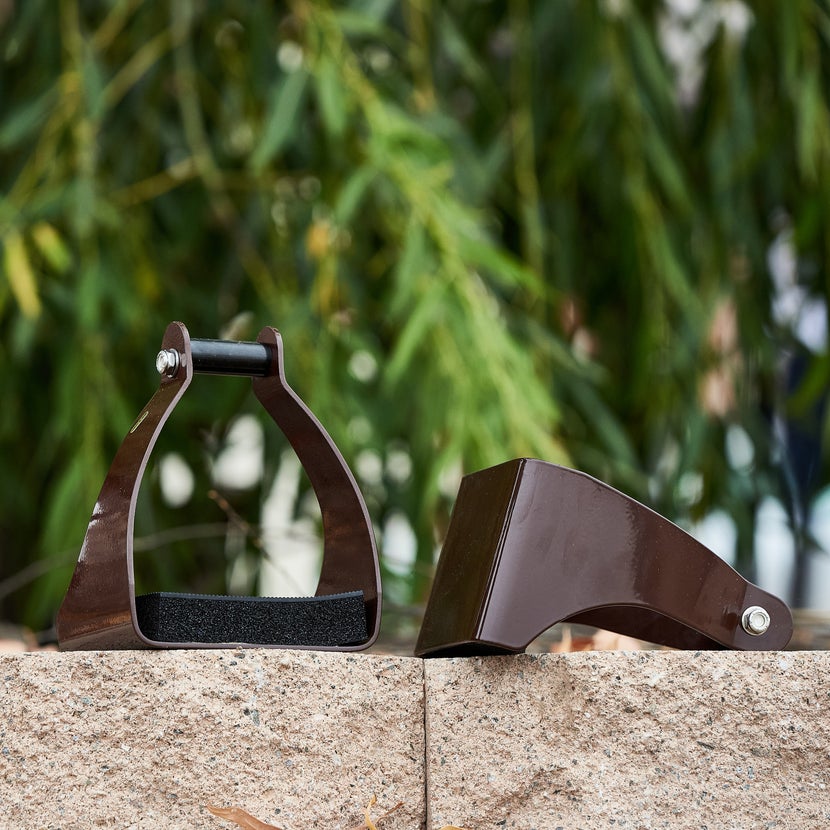 The Royal King Polymer Plastic Trail Stirrups sitting on concrete pavers. 
