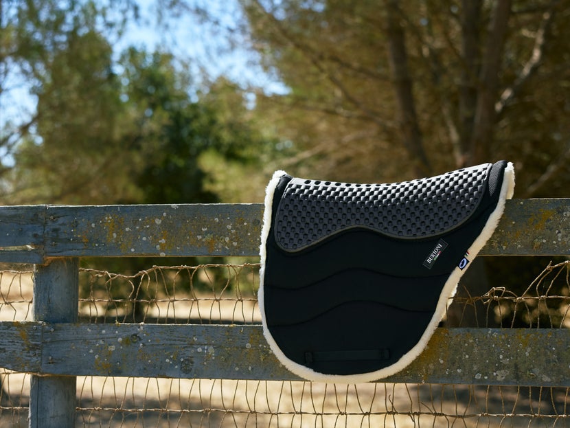 Burioni Endurance CL18 Saddle Pad sitting on a wooden fence. 