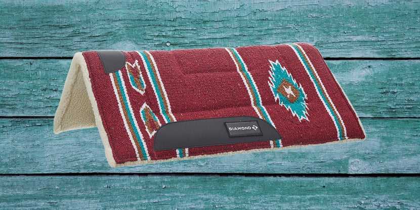 Red Reinsman Diamond R Pony Western Saddle Pad on a teal wood background