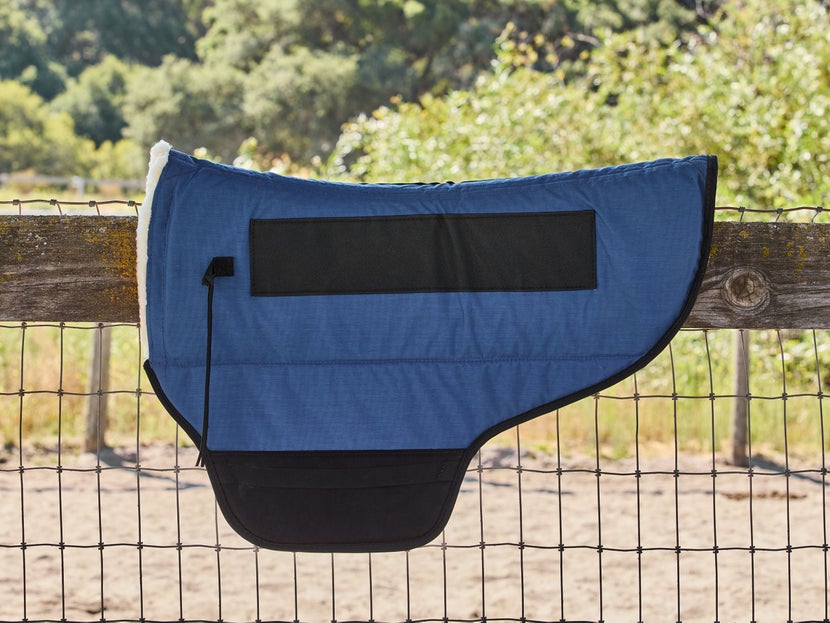 Skito Equalizer Saddle Pad for Bob Marshall Treeless Saddles sitting on a wooden fence. 