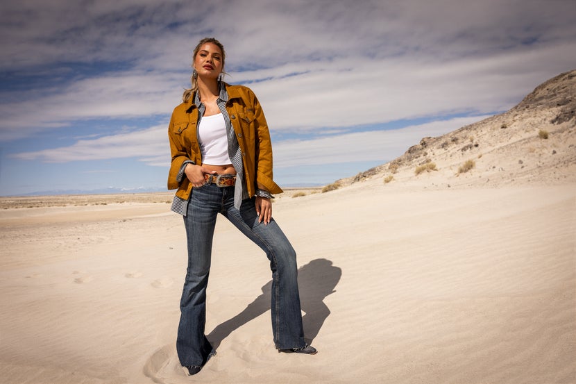 Women standing on a beach wearing the Ariat Grizzly Quilted Barn Jacket. 