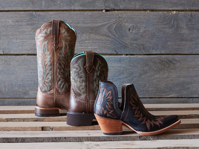 Three different cowboy boots from left to right, showing the different styles: traditional, roper, and dress boots.