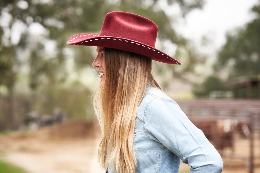Woman wearing a red cowboy hat. 