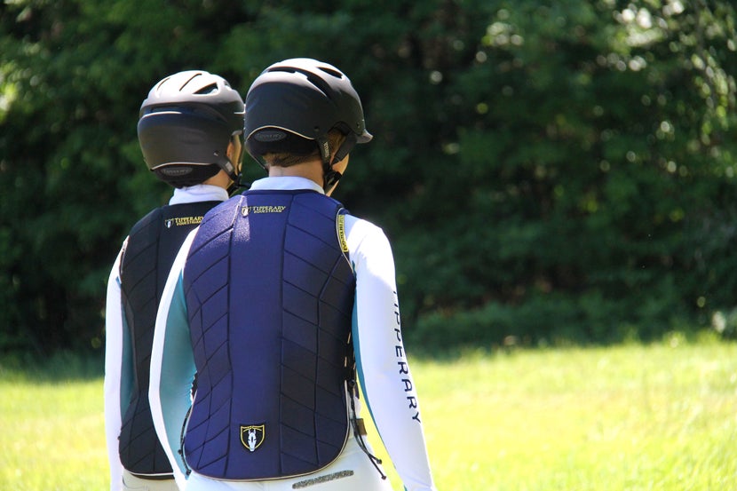 Two women walking wearing Tipperary body protectors and helmets. 