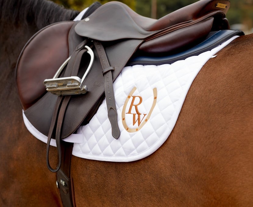 bay horse wearing an english saddle with foam half pad underneath