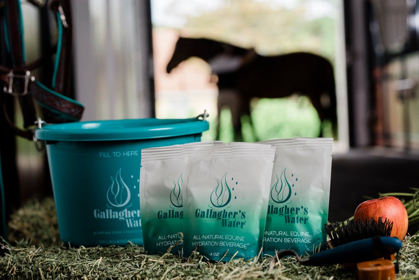 Three packets of Gallaghers Water sitting on top of a hay bale