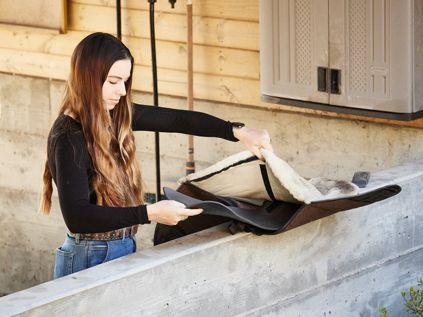 Women removing ThinLine shims from inside of saddle pad. 