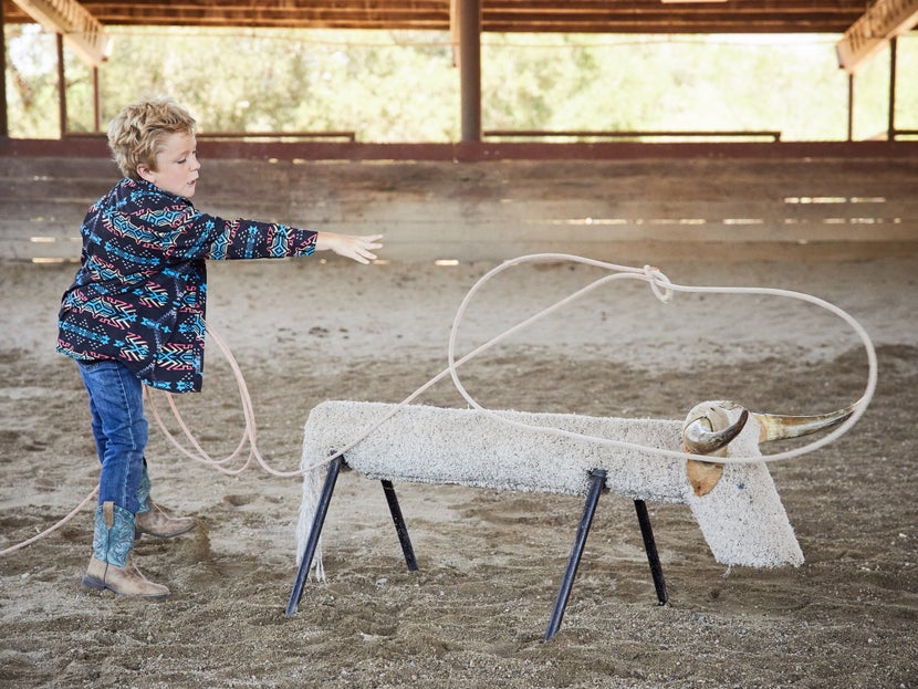 child practices roping the dummy cow