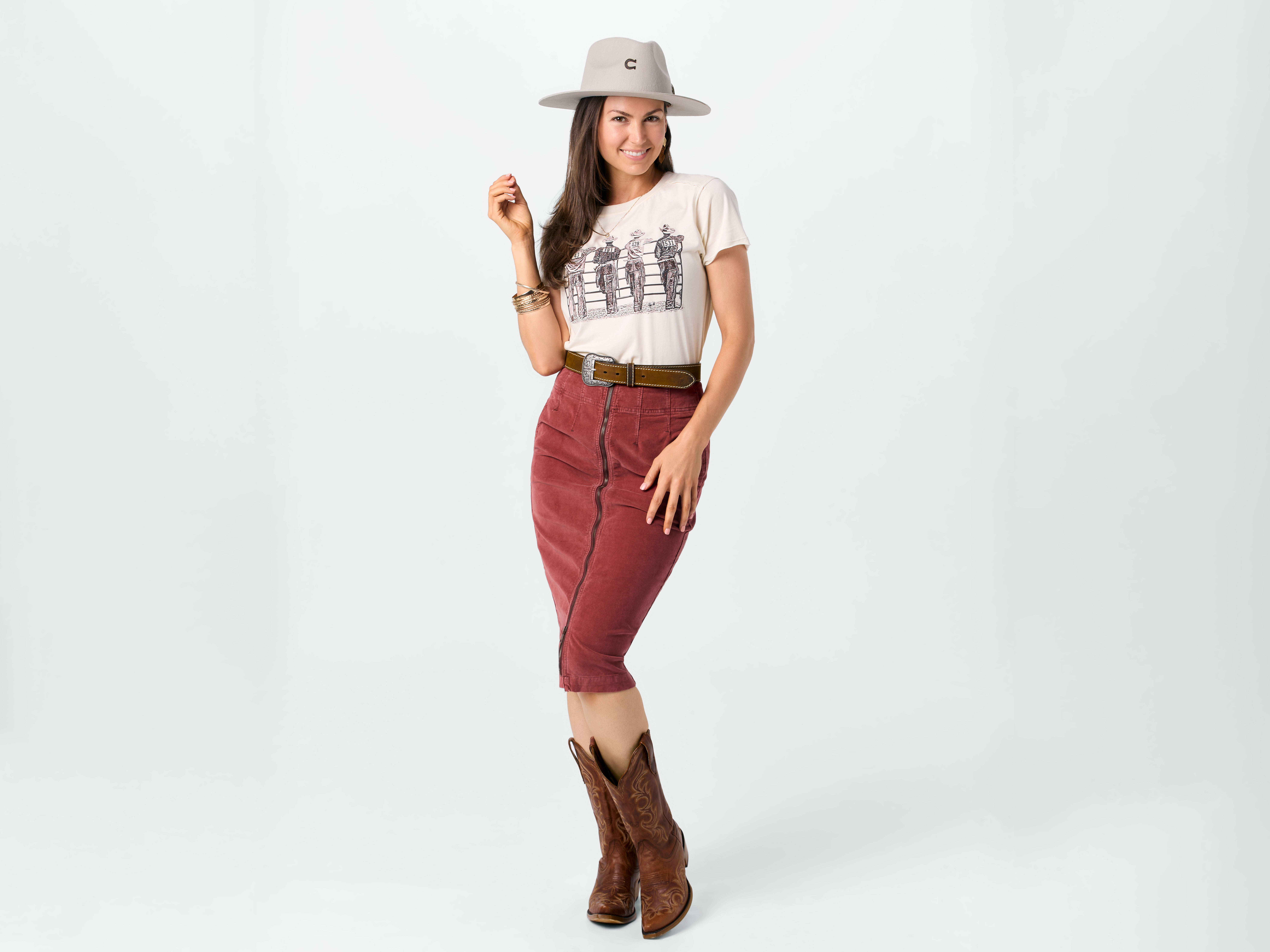 A women wearing elegant fashion cowboy boots styled with a rust colored skirt and cream shirt.