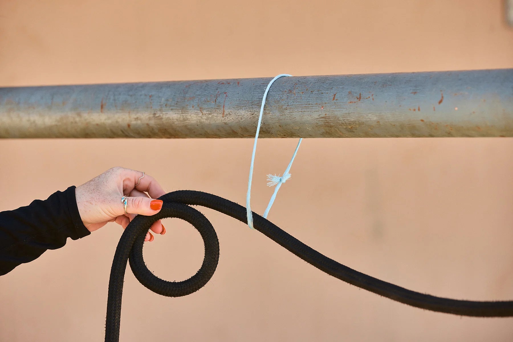 Take the tail end of your rope and put it over your rail or through your tie loop. Make a small circle with your loose end near the tie spot and hold it in place. 