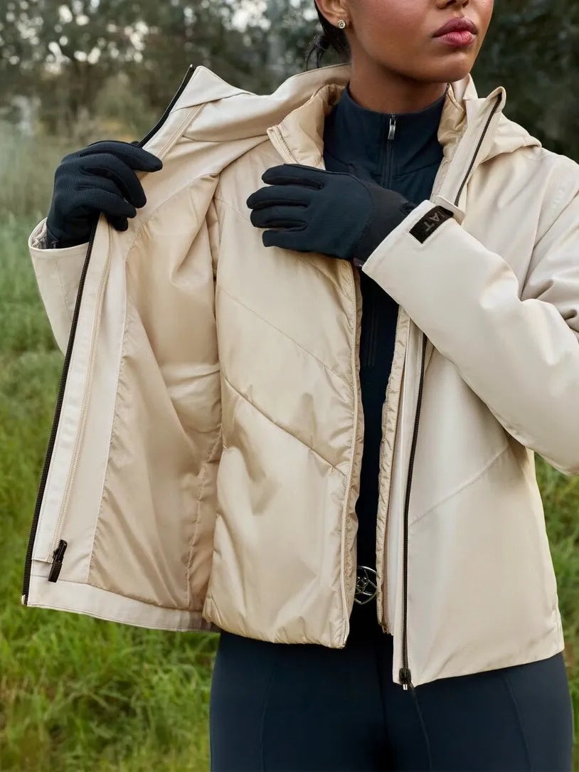 A woman wearing the Ariat Troika Jacket showing both layers.