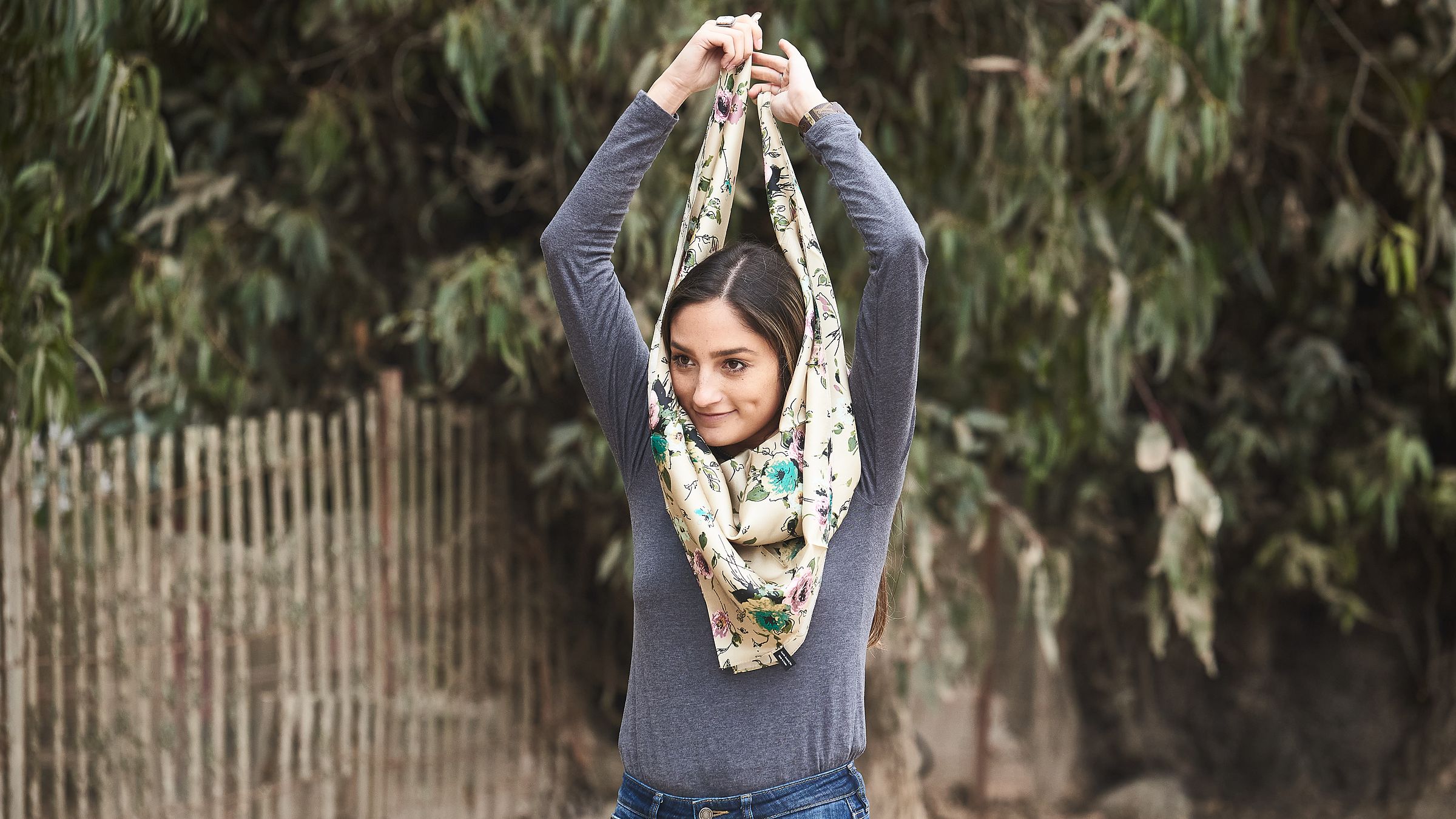 Pick up the wild rag and keep the triangle pointed downward on your chest. Bring the two ends up, over, and around your neck.