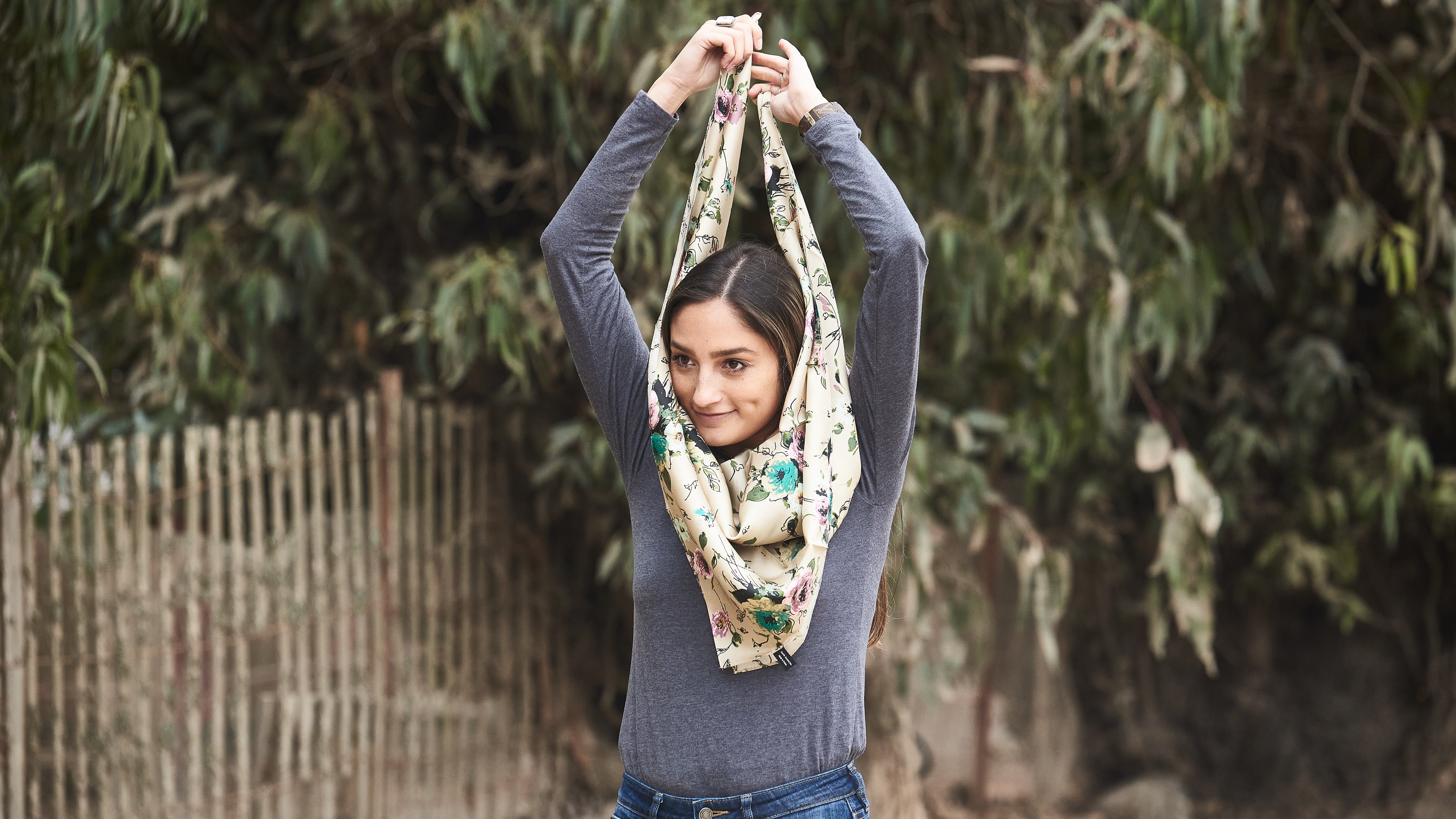 Pick up the wild rag and keep the triangle pointed downward on your chest. Bring the two ends up, over, and around your neck.
