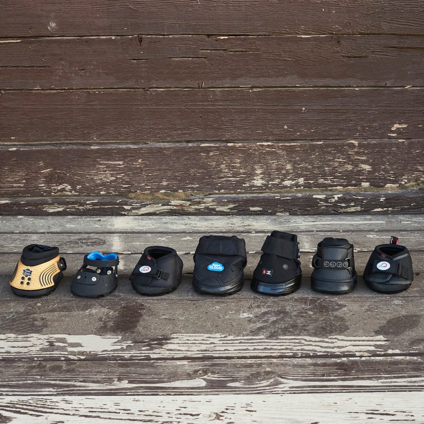 A row of different hoof boot brands and styles lined up side by side. 