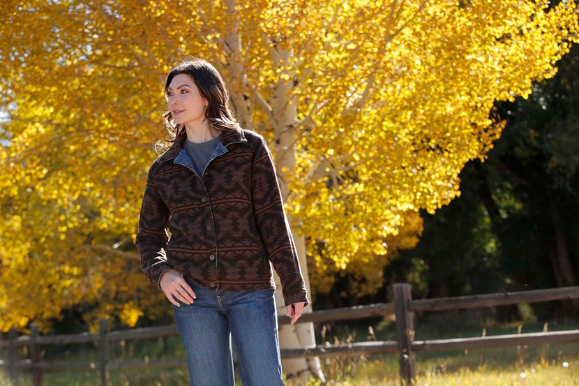 Women standing in a pasture wearing the Cinch Denim and Twill Reversible Trucker Jacket.