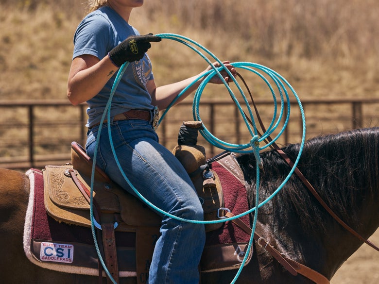 A rider sitting on a bay horse holding the Cactus Relentless Future All Around Core TX Rope